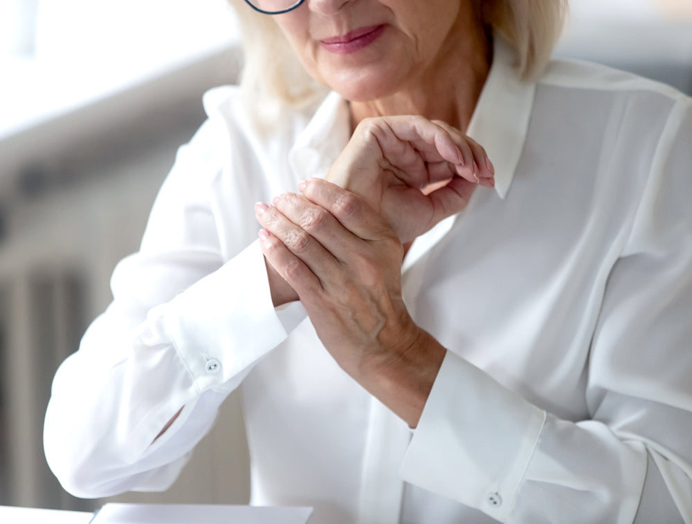Elderly woman holding her wrist